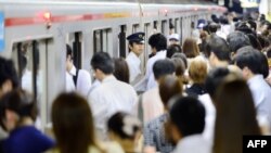 Para penumpang commuter menaiki kereta KRL Marunouchi Line pada jam sibuk pagi hari di Stasiun Ikebukuro di Tokyo, 12 Juli 2013.