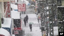 Peatones caminan sobre una vía elevada en Broadway, Nueva York, el miércoles, 21 de marzo, de 2018.