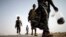 FILE - Ethiopian migrants walk on the side of a highway leading to the western Yemeni town of Haradh, on the border with Saudi Arabia.