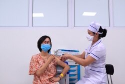 FILE - A woman receives a shot of AstraZeneca COVID-19 vaccine in Hanoi, Vietnam, June 27, 2021.