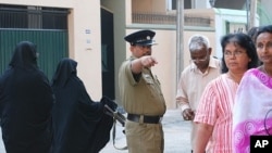 Policeman giving instruction to voters at polling station in Colombo, 26 Jan 2010