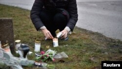 Una persona enciende una vela afuera de la escuela Risbergska, la mañana después del tiroteo en la escuela, en Orebro, Suecia, 5 de febrero de 2025. 