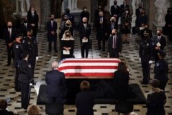Democratic presidential candidate former Vice President Joe Biden, center, and his wife Jill Biden stand as the flag-draped casket of Justice Ruth Bader Ginsburg lies in state in Statuary Hall of the U.S. Capitol, Sept. 25, 2020.