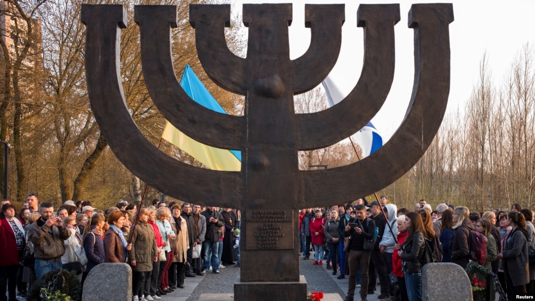 Orang-orang mengadakan pawai melawan anti-Semitisme di dekat sebuah monumen untuk memperingati para korban salah satu pembantaian tunggal terbesar Yahudi selama Holocaust Nazi, di Kyiv, Ukraina, 13 April 2018. (Foto: Reuters)