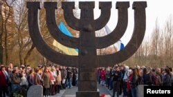 FILE - People hold a march against anti-Semitism near a monument commemorating the victims of one of the biggest single massacres of Jews during the Nazi Holocaust, in Kyiv, Ukraine, April 13, 2018. 