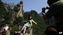 Seorang turis China tampak berpose di taman wisata Gunung Kumgang, tujuan utama wisatawan di Korea Utara (foto: dok). Pariwisata Korea Utara dari China tidak terpengaruh oleh ketegangan politik di sana. 