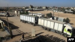 کامیون‌های حامل کمک‌های بشردوستانه به ساکنان غزه در حال عبور از گذرگاه رفح. جمعه ۳ آذر ۱۴۰۲