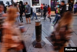 People walk near older models of traffic bollards, which the city plans to replace, after people were killed by a man driving a truck in an attack during New Year's celebrations in New Orleans, Louisiana, Jan. 2, 2025.