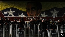 Funcionarios de la Policía Nacional Bolivariana se forman frente a un mural del Libertador Simón Bolívar en Caracas, el 31 de julio de 2024, después de dos días de protestas contra los resultados de la elección presidencial en Venezuela.