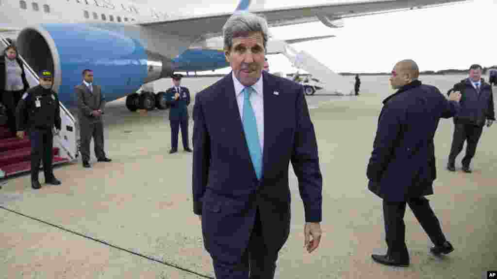 Le secrétaire d'état américain John Kerry marche sur le tarnac après son arrivée à la base militaire américaine Andrews, Maryland, le 17décembre 2014.