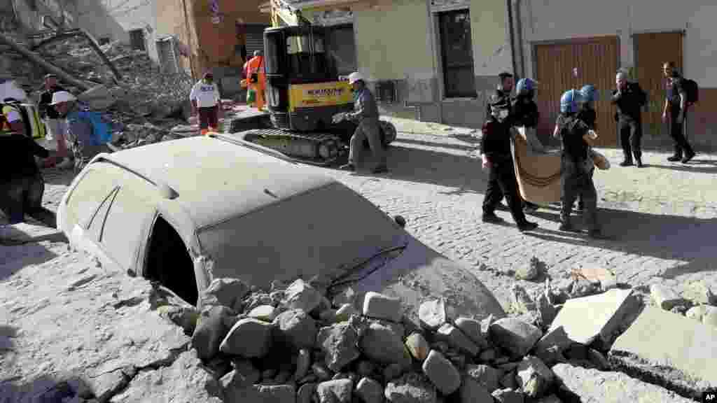 Un corps est porté en dehors des ruines, à Amatrice, Italie, le 24 août 2016.