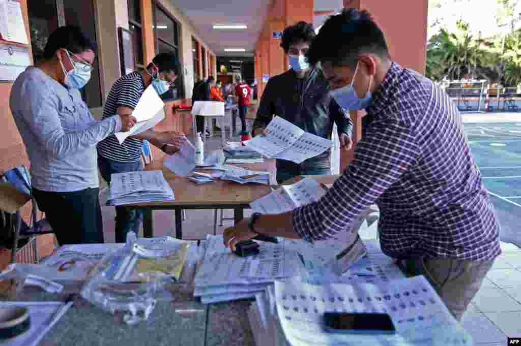 Los funcionarios electorales cuentan las papeletas despu&#233;s del cierre de las urnas durante la elecci&#243;n presidencial, en Quito, Ecuador, el 7 de febrero de 2021.