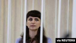 Journalist Katerina Borisevich sits inside a defendants' cage during a court hearing in Minsk, Belarus, March 2, 2021. (Sergei Sheleg/BelTA/Handout via Reuters)