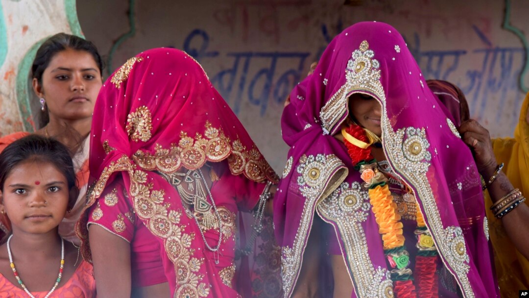 FILE - An underage bride, right, stands with family members during her marriage at a Hindu temple near Rajgarh, Madhya Pradesh state, India, April 17, 2017.