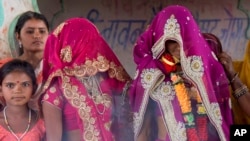 FILE - An underage bride, right, stands with family members during her marriage at a Hindu temple near Rajgarh, Madhya Pradesh state, India, April 17, 2017.