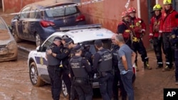  Miembros de la policía local reaccionan ante la noticia de que uno de sus colegas murió en las inundaciones en Valencia, España, el jueves 31 de octubre de 2024. AP