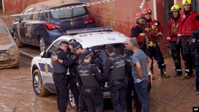  Miembros de la policía local reaccionan ante la noticia de que uno de sus colegas murió en las inundaciones en Valencia, España, el jueves 31 de octubre de 2024. AP
