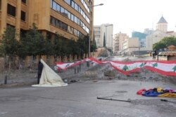 Protesters set up a new tent outside government buildings which are barricaded with barbed wire, in Beirut, Nov. 19, 2019. (Heather Murdock/VOA)