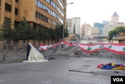 Protesters set up a new tent outside government buildings which are barricaded with barbed wire, in Beirut, Nov. 19, 2019. (Heather Murdock/VOA)