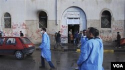 Médicos voluntarios libios pasan frente a la corte de Benghazi, tratando de atender a las personas heridas.