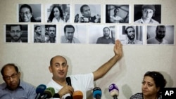 Un avocat égyptien et ancien candidat à la présidentielle, Khaled Ali, indique avec son doigt les photos des militants emprisonnés arrêtés au cours des manifestations, y compris des défenseurs des droits, au Caire, Egypte, 22 juin 2016. 