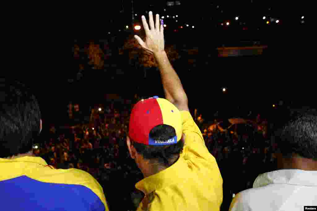 Venezuela's opposition leader Henrique Capriles waves to supporters after a news conference at his campaign headquarters in Caracas, April 15, 2013.