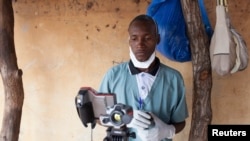 FILE - A health worker checks the temperature of a baby entering Mali from Guinea at the border in Kouremale.