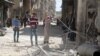 지난 11일 시리아 반군이 점령하고 있는 알레포 지역에 공습이 있은 후 주민들이 무너진 마을 터를 둘러보고 있다. 