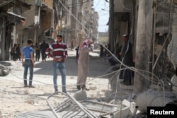 Residents inspect damages after an airstrike on the rebel-held al-Maysar neighborhood of Aleppo, Syria, April 11, 2016.