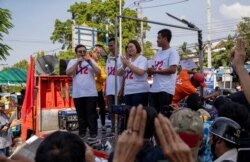 Pro-democracy movement protest leaders from left, Parit Chiwarak, Panupong Jadnok, Panusaya Sithijirawattanakul and Shinawat Chankrajang address supporters after answering charges at a police station in Northaburi, Thailand, Dec. 8, 2020.
