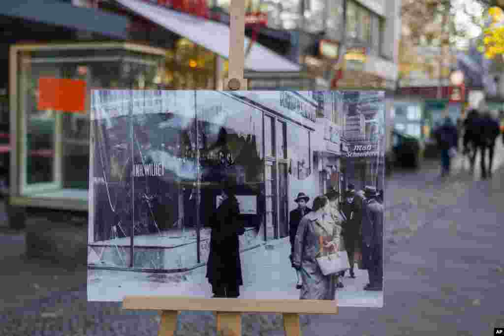 A Nov. 10, 1938 photo from the AP Archive, showing Jewish shops along Kurfuerstendamm Street destroyed by Nazis, is placed at the same location 80 years later in Berlin, Germany. On Nov. 9, 1938, Jews and their holdings were attacked across Nazi Germany — also known as Kristallnacht or night of the broken glasses. 