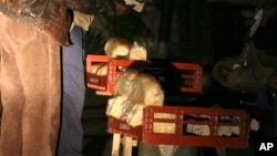 FILE: An unidentfied man buys a loaf of bread at night for 150 billion Zimbabwe dollars in Harare