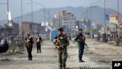 Afghan security personnel are seen at the site of bomb explosion in Kabul, Afghanistan, Feb. 26, 2020. 