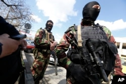 FILE - Troops without insignia, believed to be Russian soldiers, guard the center of Simferopol, Crimea, March 27, 2014.