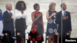 Former U.S. president Bill Clinton (L-R), Oprah Winfrey, U.S. first lady Michelle Obama, Caroline Kennedy, and U.S. President Barack Obama are pictured during the national anthem at a ceremony marking the 50th anniversary of Martin Luther King's "I have a