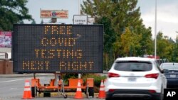 A sign directs motorists to a COVID-19 testing site, Sept. 22, 2021, in Tukwila, Wash., south of Seattle. 