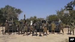 Dans cette image tirée d'une vidéo, le 31 octobre 2014, par Boko Haram, on peut voir Abubakar Shekau, au centre, leader du groupe terroriste.