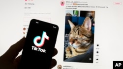 FILE - The TikTok logo is seen on a mobile phone in front of a computer screen that displays the TikTok home screen, on March 18, 2023. TikTok parent company ByteDance values itself at $300 billion, according to a report on Nov. 16, 2024.