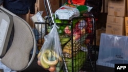 Una persona en la fila empuja su carrito lleno de alimentos en la despensa de alimentos La Colaborativa en Chelsea, Massachusetts, el 26 de noviembre de 2024. Estados Unidos celebrará el feriado de Acción de Gracias el 28 de noviembre. (Foto de Joseph Prezioso / AFP).