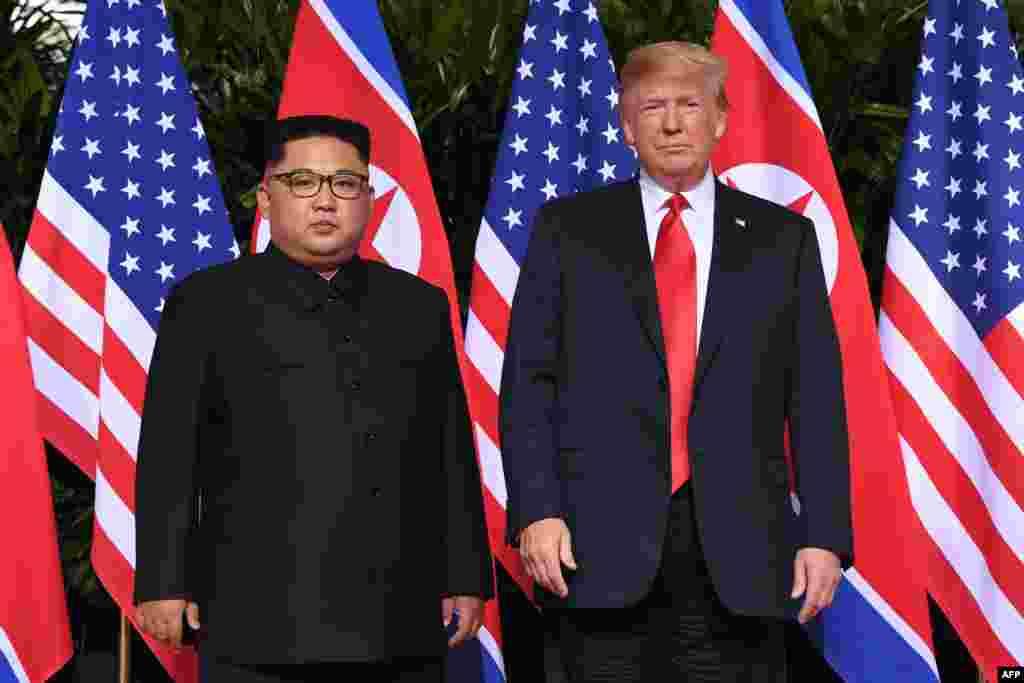 Presiden Amerika Serikat Donald Trump (kanan) dan pemimpin Korea Utara Kim Jong Un (kiri) berpose bersama dalam pertemuan bersejarah antara Amerika Serikat dan Korea Utara di Hotel Capella, Pulau Sentosa, di Singapura.(Foto: AFP)