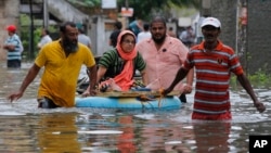 An elderly Sri Lankan woman is shifted on a makeshift raft at a flooded area in Colombo, Sri Lanka, Tuesday, May 17, 2016. The Disaster Management Center said that 114 homes have been destroyed and more than 137,000 people have been evacuated to safe locations as heavy rains continue. (AP Photo/Eranga Jayawardena)