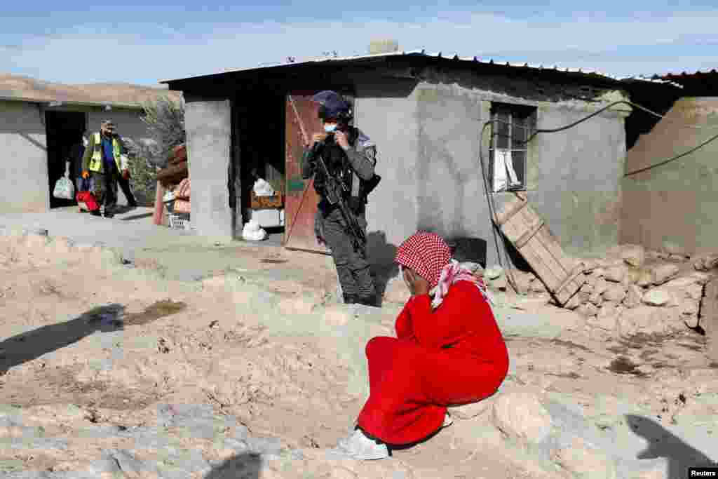 A Palestinian woman reacts as Israeli forces prepare to demolish her home, in Yatta in the Israeli-occupied West Bank.