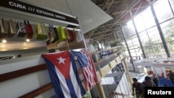 FILE - U.S. and Cuban flags hang side by side at the U.S pavilion during the Havana International Fair (FIHAV) in Cuba, Nov. 2, 2015. 
