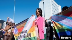 Watu wameshikilia mabango kuunga mkono haki za LGBTQ nje ya mahakama kuu ambayo ilifanya uamuzi wa kihistoria kupendelea jumuiya za wapenzi wa jinsia moja huko Windhoek, Namibia, Juni 21, 2024
