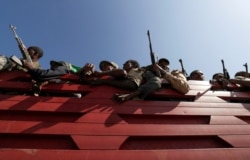 FILE - Members of Amhara region militias ride on their truck as they head to face the Tigray People's Liberation Front, in Sanja, Amhara region near a border with Tigray, Ethiopia, Nov. 9, 2020.