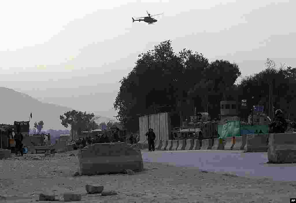 Afghan National Army soldiers keep watch as a NATO helicopter flies over the site of a car bomb attack in Jalalabad on February 27, 2012. (Reuters)