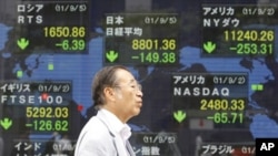A man walks by an electronic stock board of a securities firm in Tokyo, September 5, 2011.