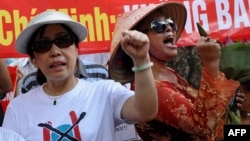 FILE - Bui Thi Minh Hang (R), 47, shouting anti-China slogans next to dissident lawyer Cu Huy Ha Vu's wife, Nguyen Thi Duong Ha (L), during an anti-China protest in downtown Hanoi.