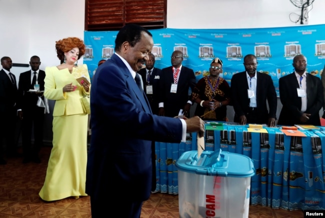 FILE - Cameroonian President Paul Biya casts his ballot while his wife Chantal Biya watches at a polling station during the presidential election in Yaounde, Cameroon, Oct. 7, 2018.