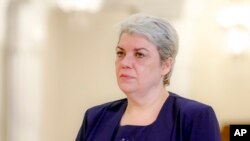 FILE - Sevil Shhaideh, 52, stands at the Romanian presidency before being sworn in as regional development minister in Bucharest, Romania.